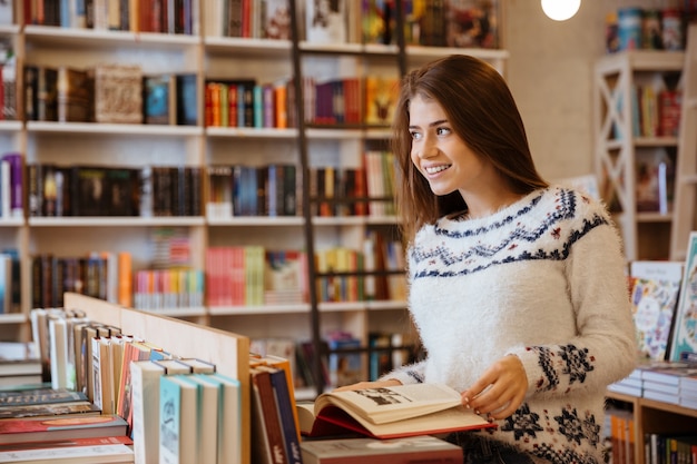 Portrait of a pretty young woman standing in a book store