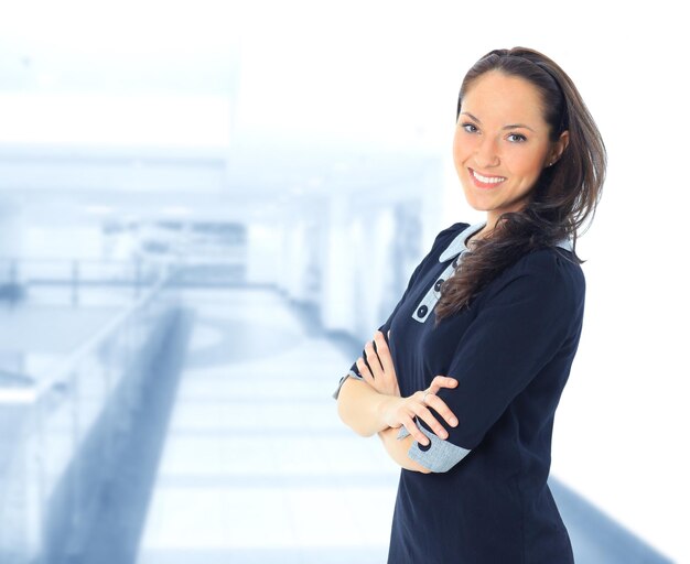 Portrait of a pretty young woman standing with folded hands on white background