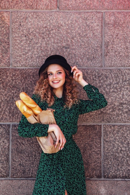 Portrait pretty young woman with baguette in hands