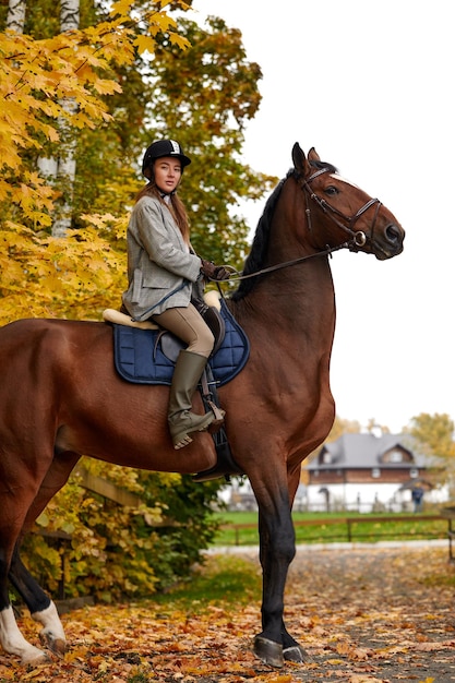 Ritratto di una donna abbastanza giovane con una giornata autunnale di equitazione marrone