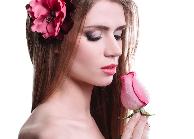 Portrait of a pretty young woman with a delicate rose