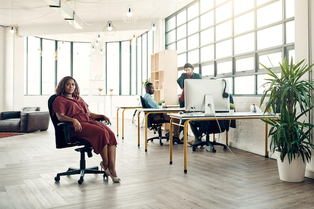 肖像画のプライドとオフィスの上司の椅子に座る黒人女性で、プロジェクトやデザイン会社の起業家のための創造的なアイデアを持っています。創造性のアイデアを持つリーダーと、仕事に誇りを持っているアフリカの実業家
