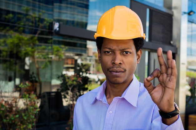 Portrait of professional architect in protective yellow helmet . Engineer and architect concept.