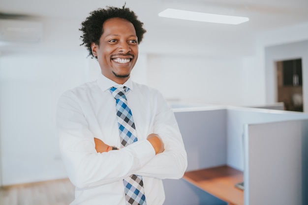 Portrait of professional businessman smiling while standing at modern office.