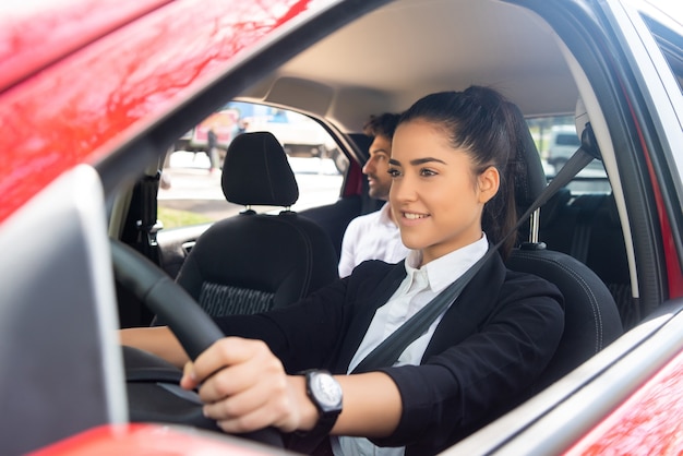 彼女の車を運転するプロの女性ドライバーの肖像画。輸送の概念。