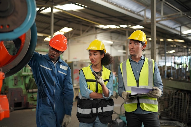 Ritratto di ingegnere/lavoratore professionista dell'industria pesante che indossa uniforme di sicurezza, occhiali e elmetto. sullo sfondo sfocato grande fabbrica industriale