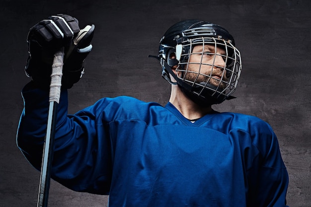 Portrait of a professional ice-hockey player in a hockey uniform. Studio shot.