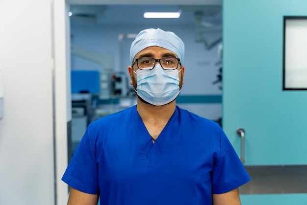 Portrait of the professional medical assistant in surgical mask during operation Modern hospital operating room