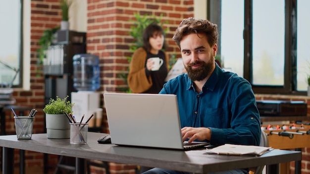 Portrait of project manager sending professional email on laptop