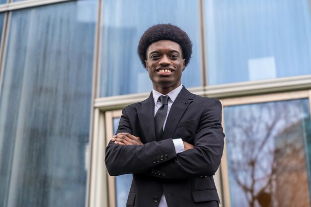 Photo portrait of proud african businessman standing outside a financial building