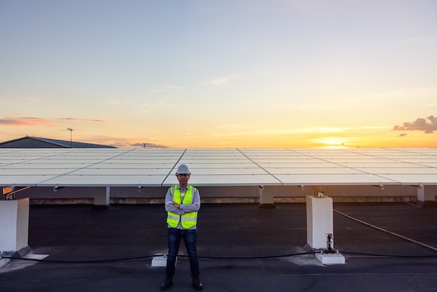 The portrait of a proud young engineer smiles satisfied with his successful work on roof , renewable energy, technology, electricity, service, green power.