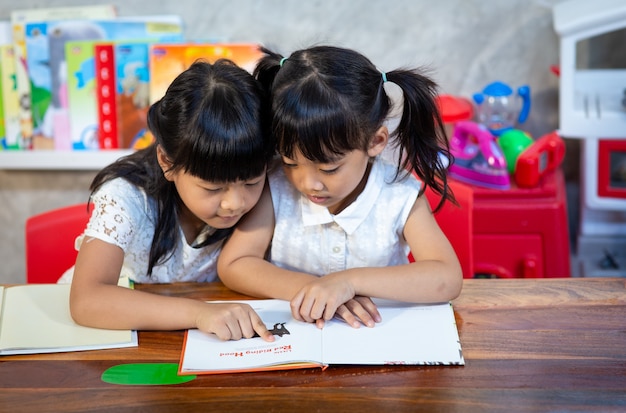 Portrait of pupils looking at page reading lesson