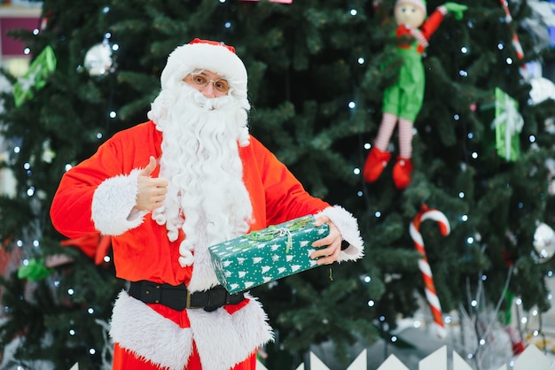 Portrait real authentic Santa Claus with Christmas gifts in hands in Shopping Mall