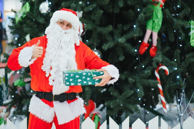 Portrait real authentic Santa Claus with Christmas gifts in hands in Shopping Mall