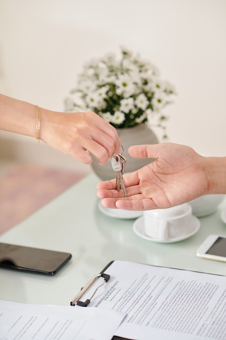 Photo portrait of real estate agent giving house keys to young man after signing residential lease agreement