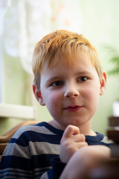 Foto ritratto di un ragazzo emotivo dai capelli rossi di otto anni