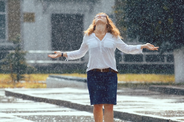 Portrait of redhaired happy woman in the rain