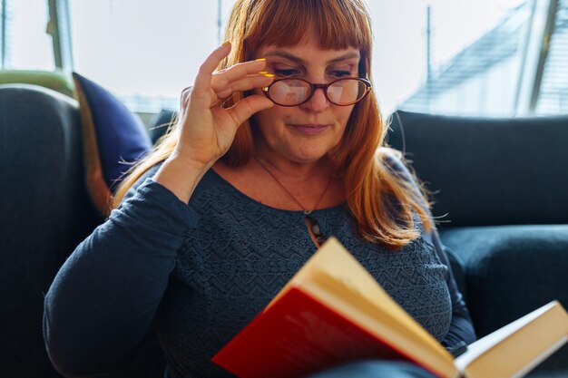 Photo portrait redhaired woman reading novel book