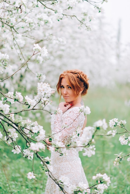 Portrait of a redhaired woman in white blossom