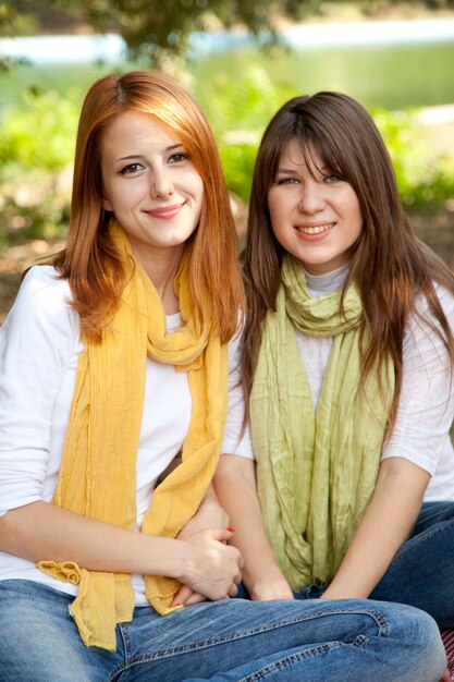 Portrait of redhead and brunette girls at outdoor. Autumn.