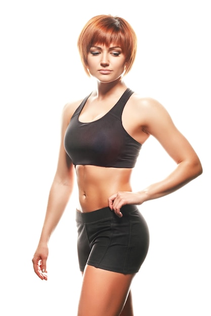 Portrait of redhead woman in sportswear. Studio shot, isolated, white background