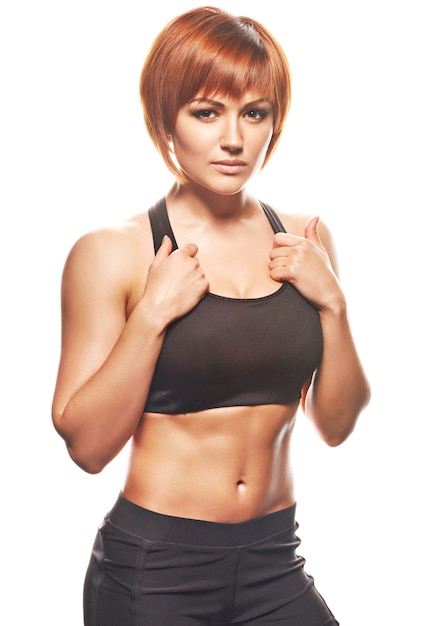 Portrait of redhead woman in sportswear. Studio shot, isolated, white background