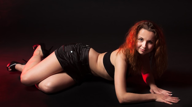 Portrait of redhead woman with long hair on dark background