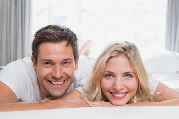 Portrait of a relaxed casual couple smiling in bed