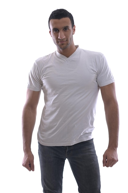 スタジオで白い背景の上に分離された白いシャツとジーンズに身を包んだリラックスした若い男の肖像画