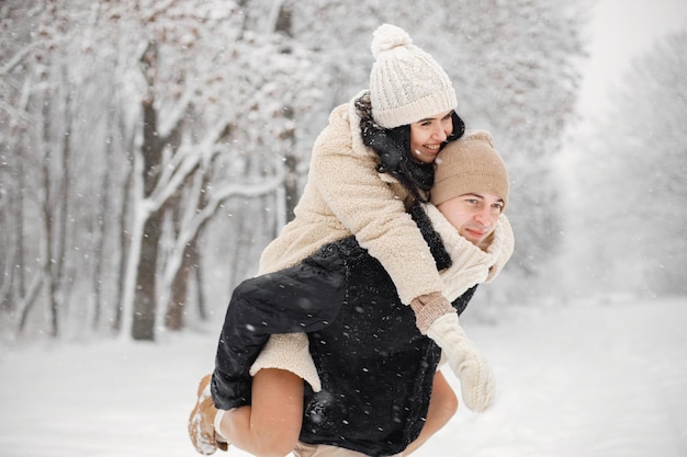 Portrait of romantic couple spending time together in forest at winter day