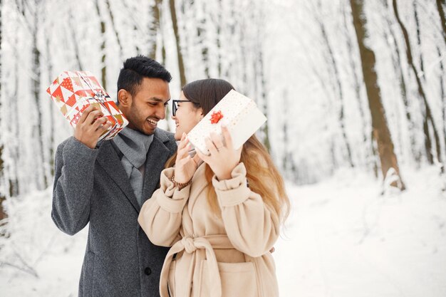 Portrait of a romantic couple spending time together in winter forest