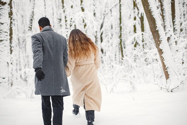 Portrait of a romantic couple spending time together in winter forest