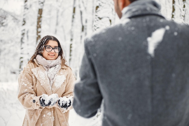 Portrait of a romantic couple spending time together in winter forest