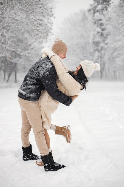 Portrait of romantic couple walking in forest at winter day