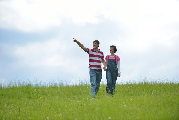 Portrait of romantic young couple in love smiling together outdoor in nature with blue sky in background