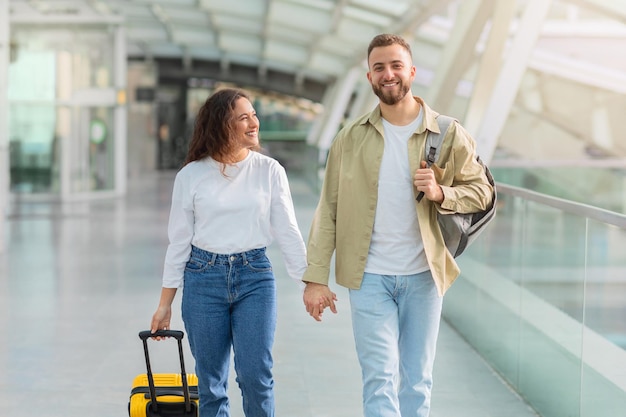 portrait of romantic young couple walking together in airport terminal