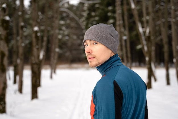 Portrait of a runner from the back dressed in warm sportswear and preparing to run