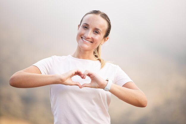 Photo portrait runner and hand sign by woman with heart symbol or gesture for wellness against blurred background face happy and girl with emoji hands shape and message for self love peace and care