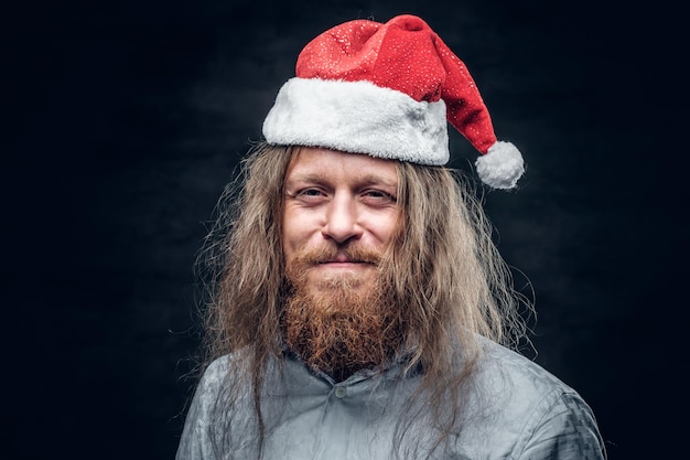 Portrait of sad bearded man in santa's hat.