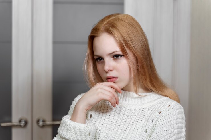 Фотография портрет грустной красивой 16-летней кавказской девушки в белом вязаном свитере