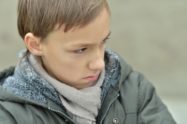 Photo portrait of a sad boy outdoors in park