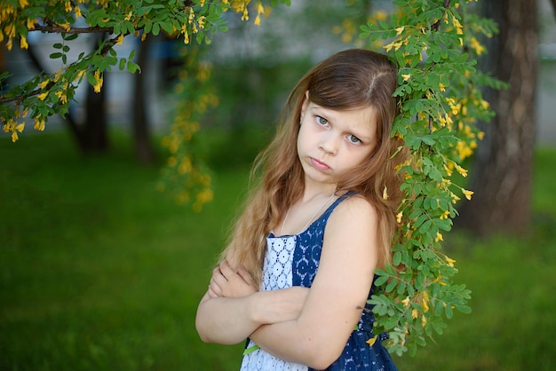 Portrait of sad girl in dress in park