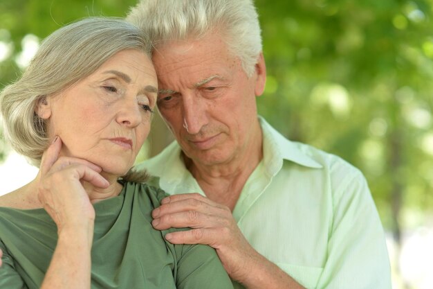 Portrait of sad senior couple in autumn park