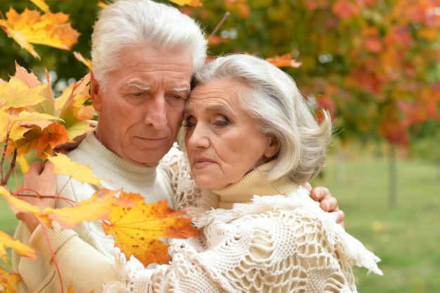 Portrait of sad senior couple hugging outdoors