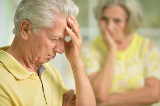 Portrait of sad senior man and woman on background