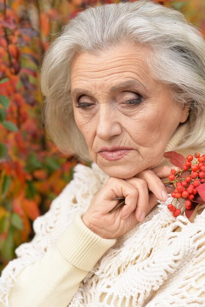 Portrait of sad senior woman in autumn park