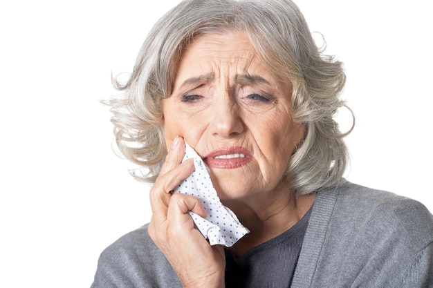 Portrait of sad senior woman with toothache posing on white background