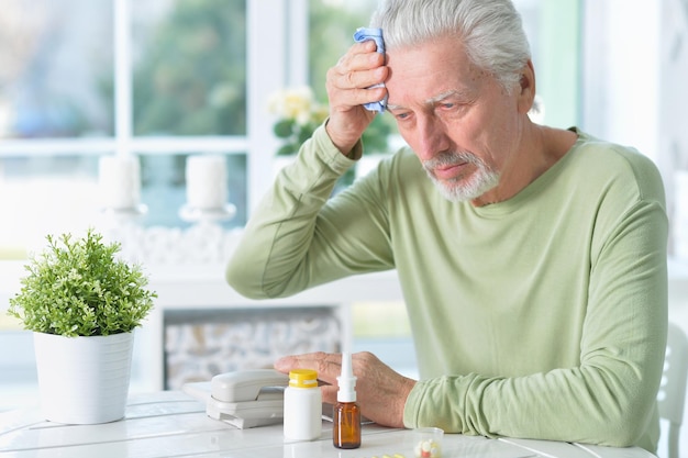 Портрет грустного больного пожилого человека с головной болью дома