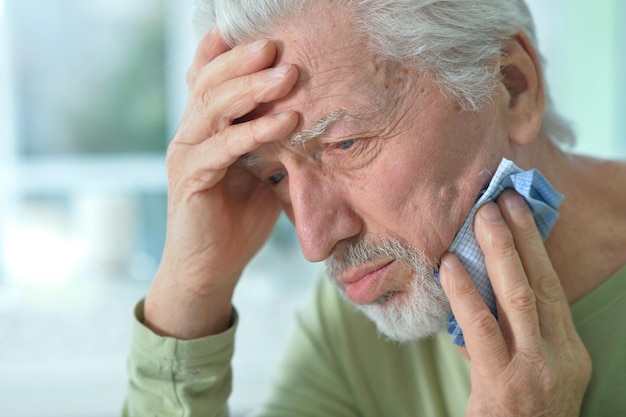 Portrait of sad sick senior man with toothache