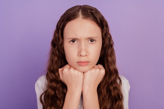 Portrait of sad unhappy grumpy little lady fists chin frustrated look camera on purple background